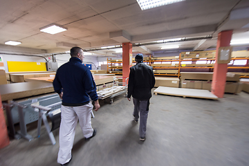 Image showing two young carpenters working in big modern carpentry