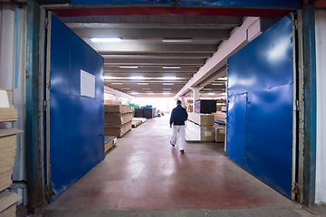 Image showing carpenter walking through factory