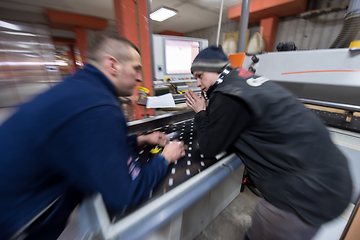 Image showing carpenters calculating and programming a cnc wood working machin