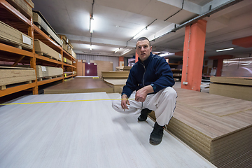 Image showing carpenter measuring wooden board