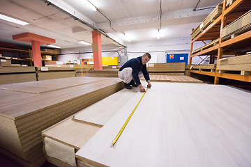 Image showing carpenter measuring wooden board