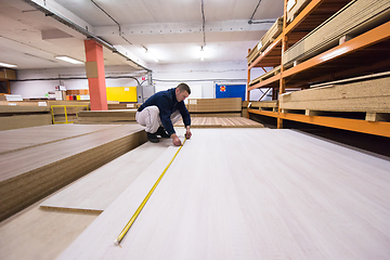 Image showing carpenter measuring wooden board