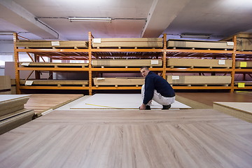 Image showing carpenter measuring wooden board