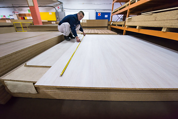 Image showing carpenter measuring wooden board