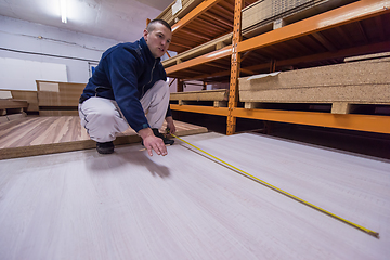 Image showing carpenter measuring wooden board