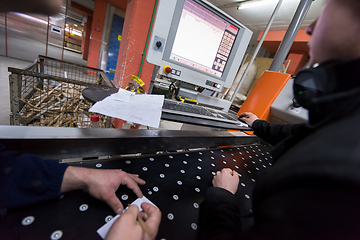 Image showing carpenters calculating and programming a cnc wood working machin