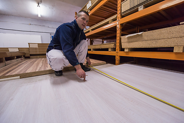 Image showing carpenter measuring wooden board