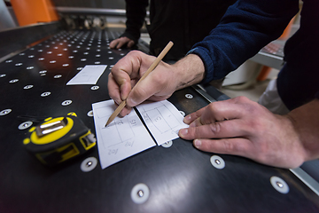 Image showing carpenters calculating and programming a cnc wood working machin