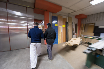 Image showing two young carpenters working in big modern carpentry