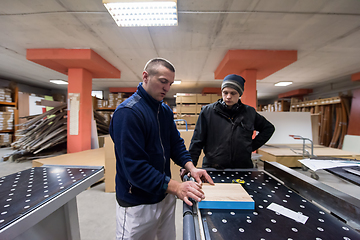 Image showing carpenters calculating and programming a cnc wood working machin