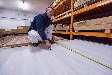 Image showing carpenter measuring wooden board