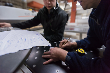 Image showing carpenters calculating and programming a cnc wood working machin