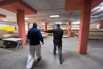 Image showing two young carpenters working in big modern carpentry