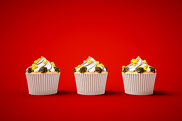 Image showing three cupcakes on red background