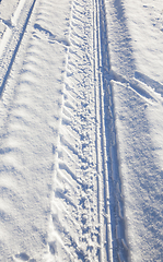 Image showing trace of the car wheels on snow close-up