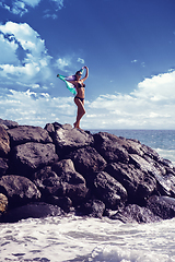 Image showing beautiful girl standing on rocky shore