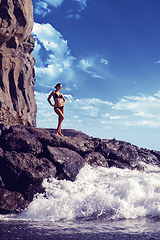 Image showing beautiful girl standing on rocky shore