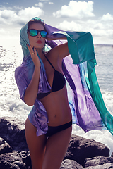 Image showing beautiful girl standing on rocky shore