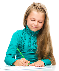 Image showing Little girl is drawing using pencils