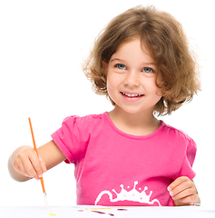 Image showing Little girl is painting with gouache