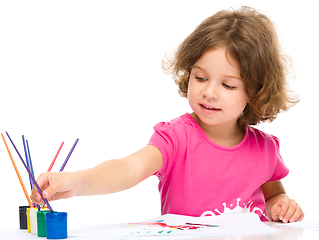 Image showing Little girl is painting with gouache