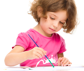 Image showing Little girl is painting with gouache