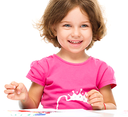 Image showing Little girl is painting with gouache