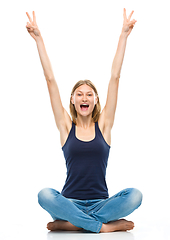 Image showing Young happy woman is sitting on the floor