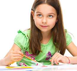 Image showing Little girl is painting with gouache