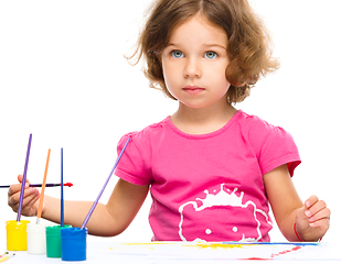 Image showing Little girl is painting with gouache