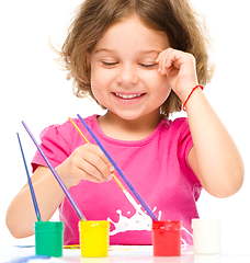 Image showing Little girl is painting with gouache