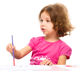 Image showing Little girl is painting with gouache