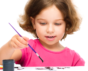 Image showing Little girl is painting with gouache