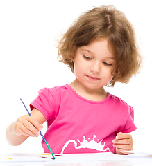 Image showing Little girl is painting with gouache