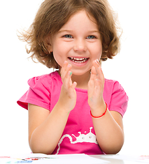 Image showing Little girl is painting with gouache