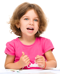 Image showing Little girl is painting with gouache