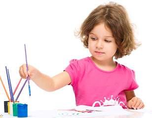 Image showing Little girl is painting with gouache