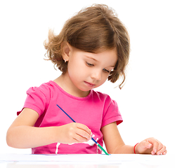 Image showing Little girl is painting with gouache