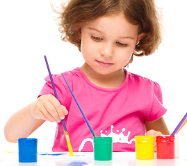 Image showing Little girl is painting with gouache