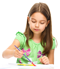 Image showing Little girl is painting with gouache