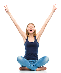 Image showing Young happy woman is sitting on the floor