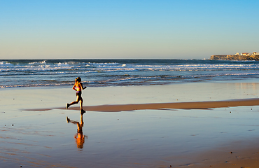 Image showing Woman running ocean beach sunset