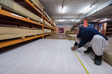 Image showing carpenter measuring wooden board