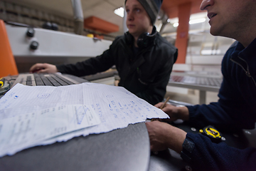 Image showing carpenters calculating and programming a cnc wood working machin