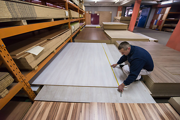 Image showing carpenter measuring wooden board