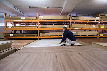 Image showing carpenter measuring wooden board