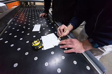 Image showing carpenters calculating and programming a cnc wood working machin