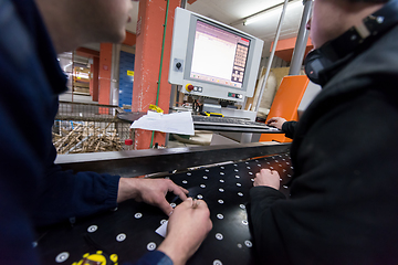 Image showing carpenters calculating and programming a cnc wood working machin