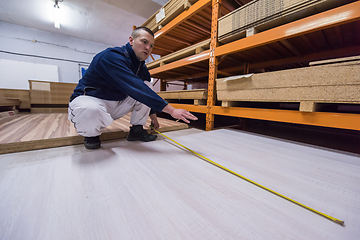 Image showing carpenter measuring wooden board