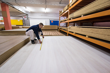 Image showing carpenter measuring wooden board